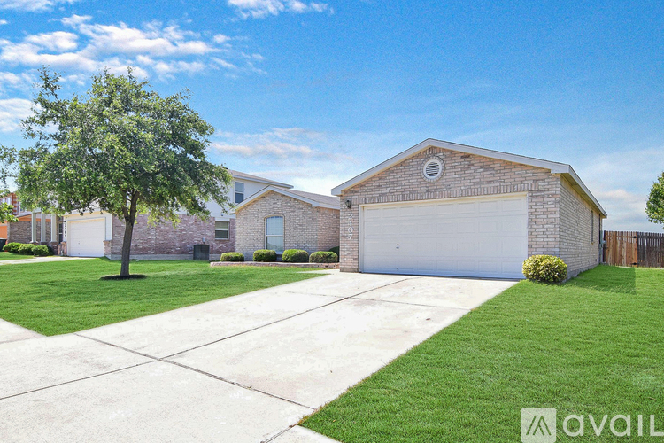 A house with a garage and a tree in front.