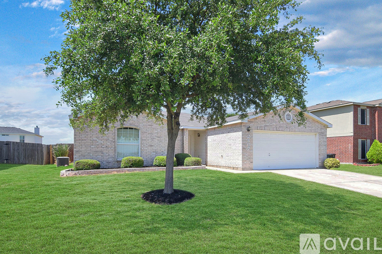 A tree in a yard in front of a house.