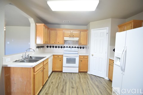 A kitchen with wooden cabinets and a white refrigerator.