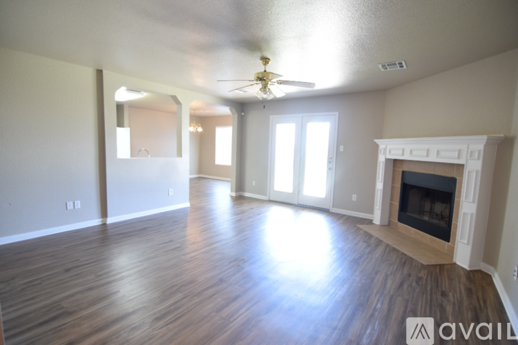 A spacious living room with wood flooring and a fireplace.