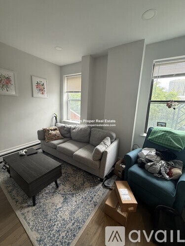 A living room with a grey couch, a coffee table, and a rug.