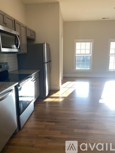 A kitchen with stainless steel appliances and wooden floors.