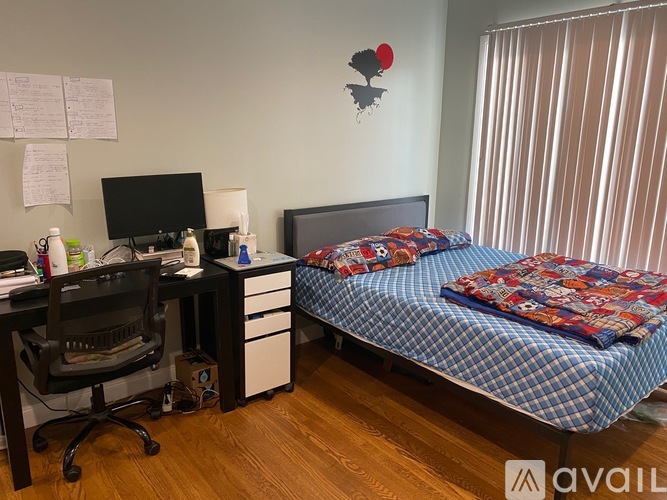 A bedroom with a bed, desk, and chair.