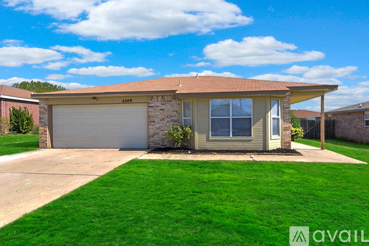 A house with a garage and a driveway in front.