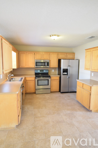 A kitchen with wooden cabinets and a tile floor.