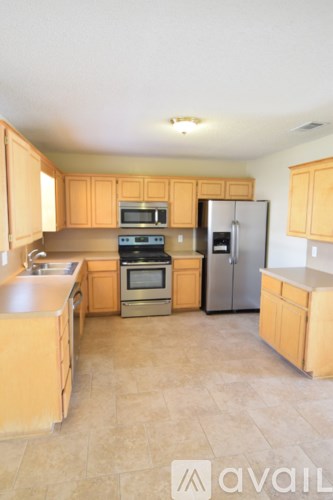 A kitchen with wooden cabinets and a tile floor.