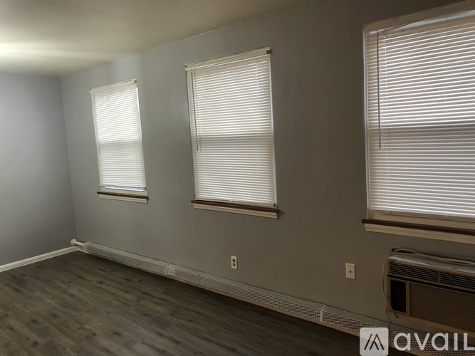A room with two windows and a wall-mounted air conditioning unit.