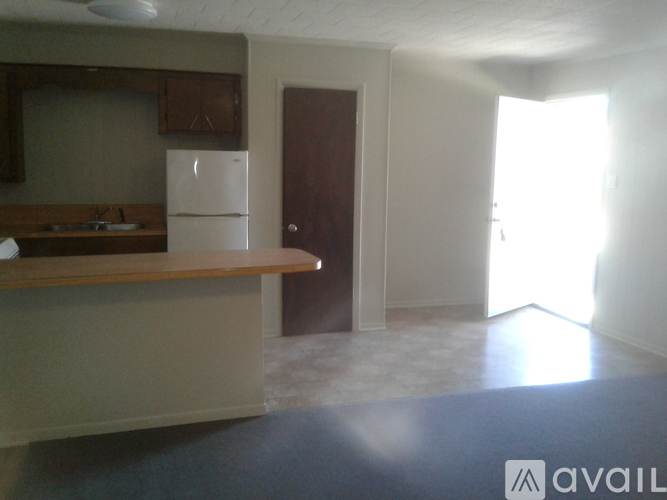 A kitchen with a white fridge and wooden cabinets.