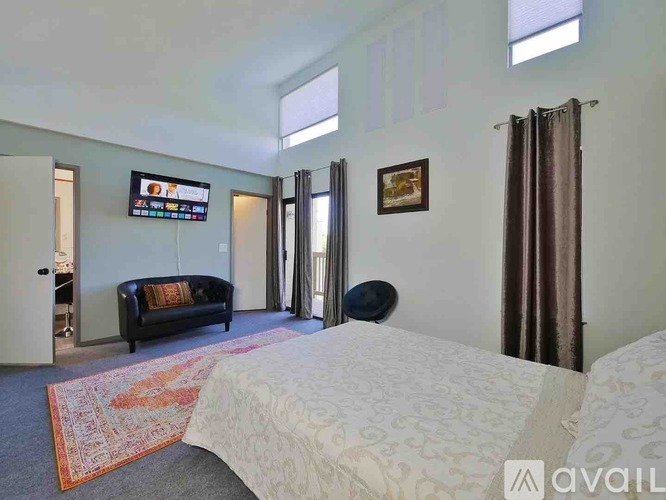 A bedroom with a large bed and a couch.