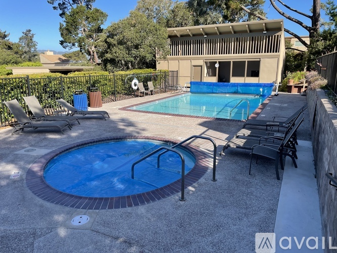 A pool with a hot tub in the middle of a backyard.