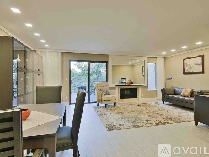 A modern living room with a fireplace and a dining table.