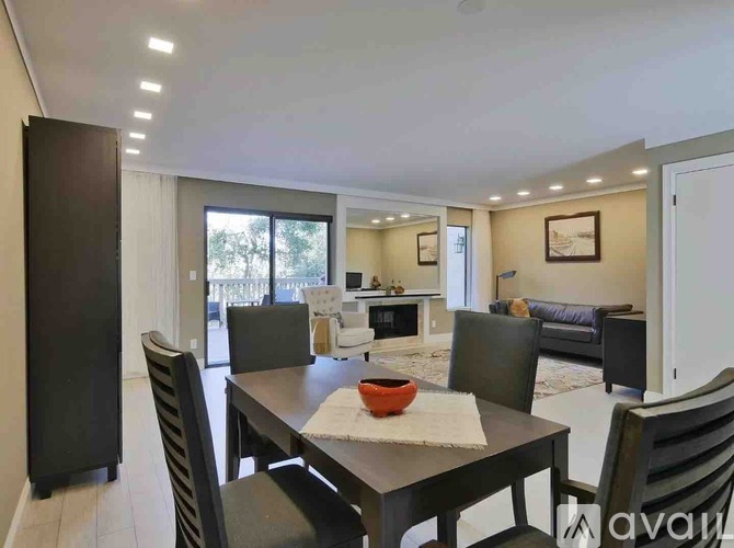 A modern dining room with a table set for four.
