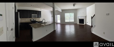 A spacious kitchen with black cabinets and a brown countertop.