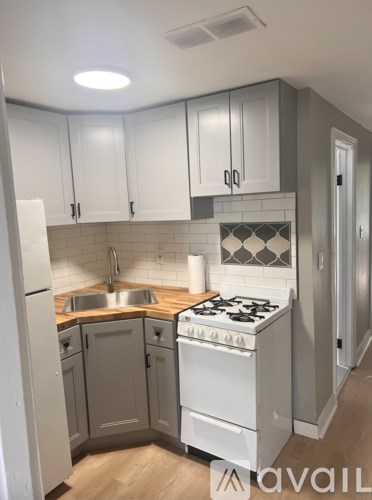 A kitchen with white cabinets and a white stove top oven.
