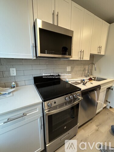 A kitchen with white cabinets and a black stove top.