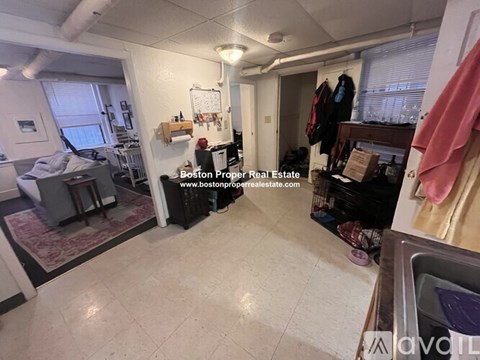 A room with a washing machine and a sink.