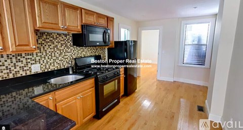 A kitchen with wooden cabinets and a black stove top oven.
