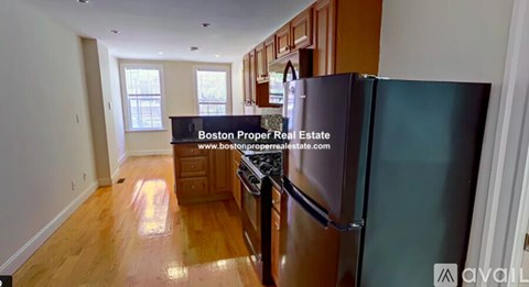 A kitchen with a refrigerator and a website address on the wall.