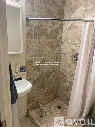 A bathroom with a shower curtain and a white sink.