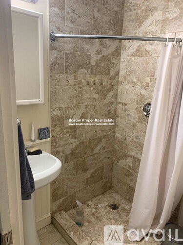 A bathroom with a shower curtain and a white sink.