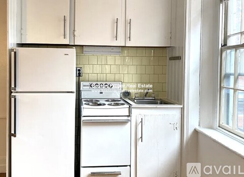 A kitchen with white appliances and cabinets.