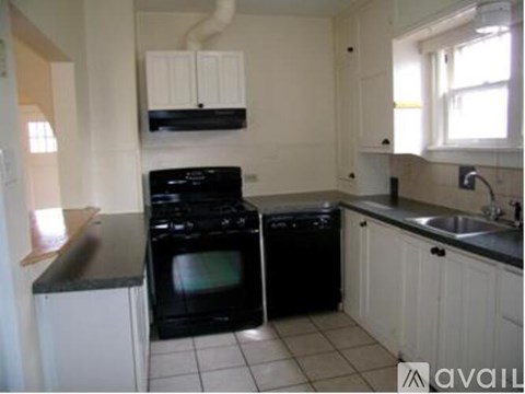 A kitchen with black appliances and white cabinets.