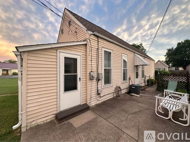 A house with a patio and a chair is for sale.