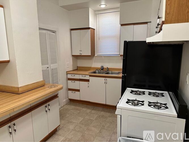 A kitchen with white cabinets and a black oven.