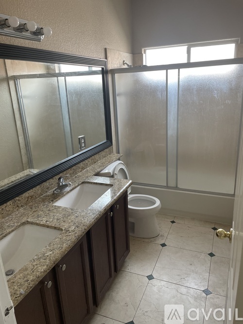 A bathroom with a sink, mirror, toilet and shower.