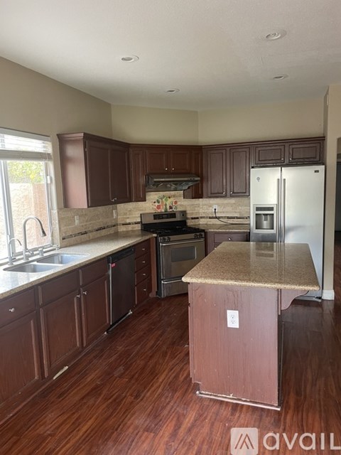A kitchen with brown cabinets and a granite countertop.