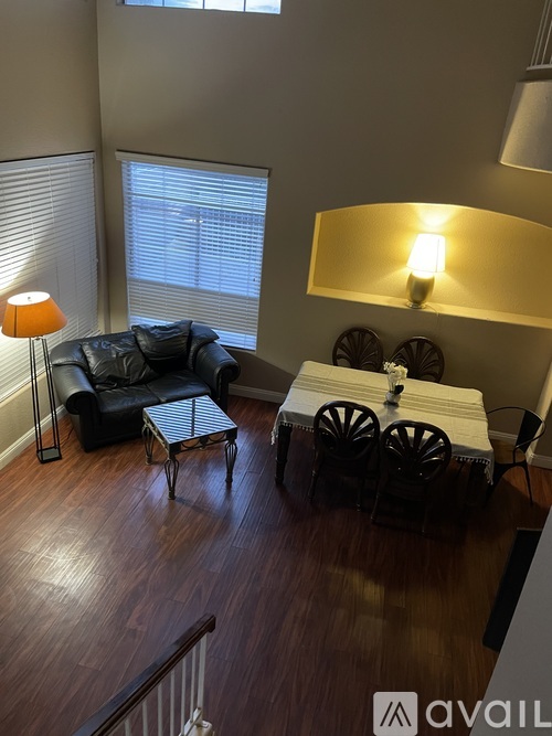 A living room with a black couch, a white table, and a lamp.