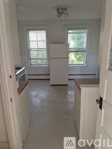 A kitchen with white appliances and cabinets.