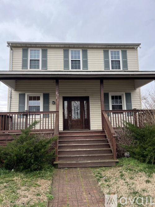 A two-story house with a front porch and stairs leading up to the door.