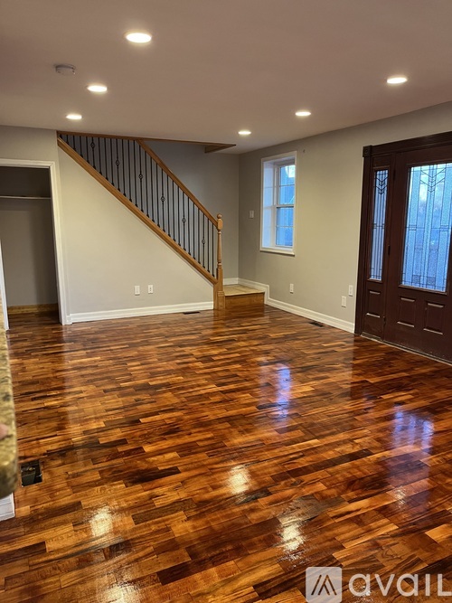 A room with wooden flooring and a staircase.