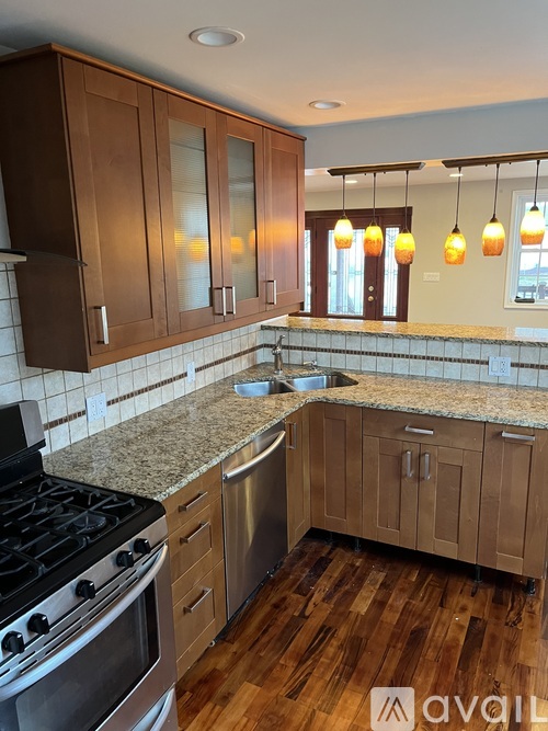 A kitchen with wooden cabinets and a granite countertop.