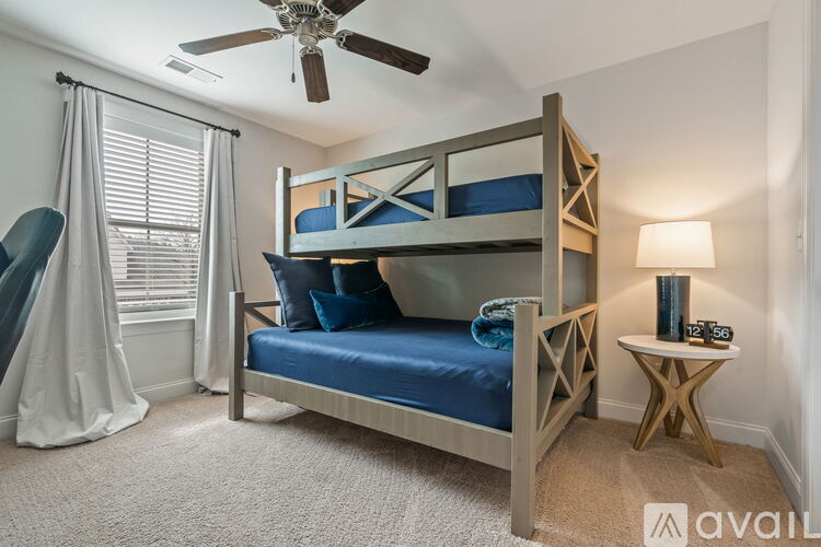 A bedroom with a bunk bed and a ceiling fan.