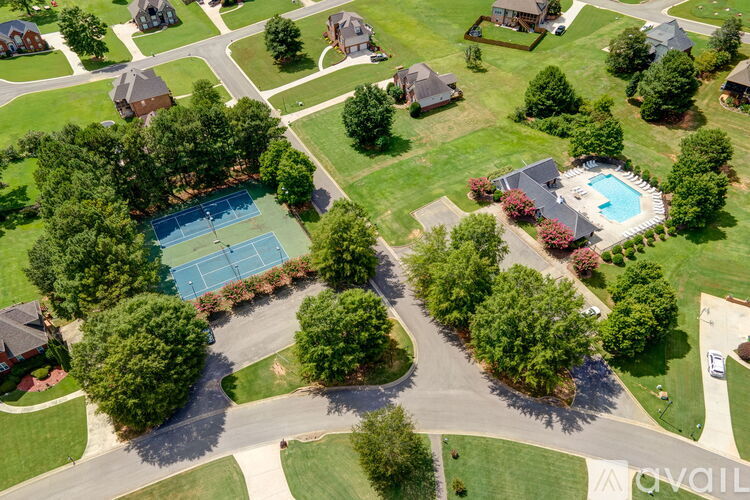 A bird's eye view of a neighborhood with a tennis court and a pool.