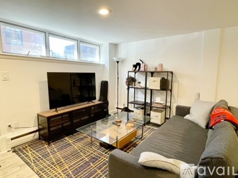 A living room with a grey couch and a glass coffee table.