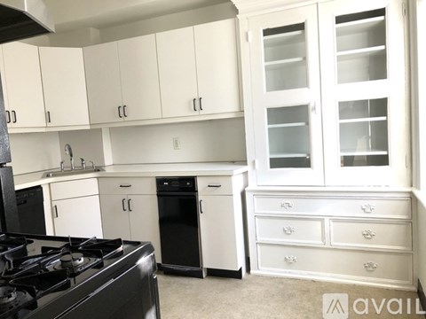 A kitchen with white cabinets and black appliances.