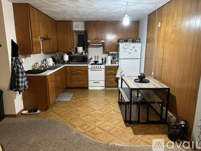 A kitchen with wooden cabinets and a white fridge.