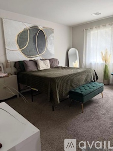 A bedroom with a bed, a bench, and a mirror.