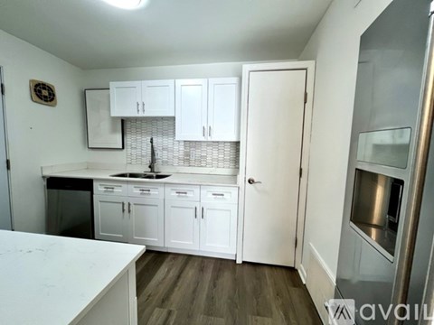 A kitchen with white cabinets and a white countertop.