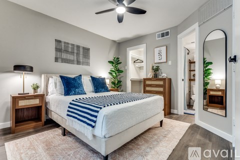 A bedroom with a large bed and a ceiling fan.
