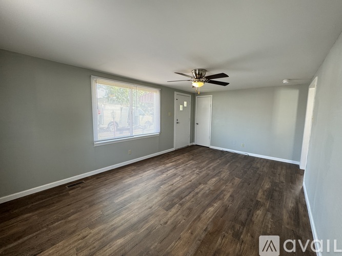 A room with wooden flooring and a ceiling fan.
