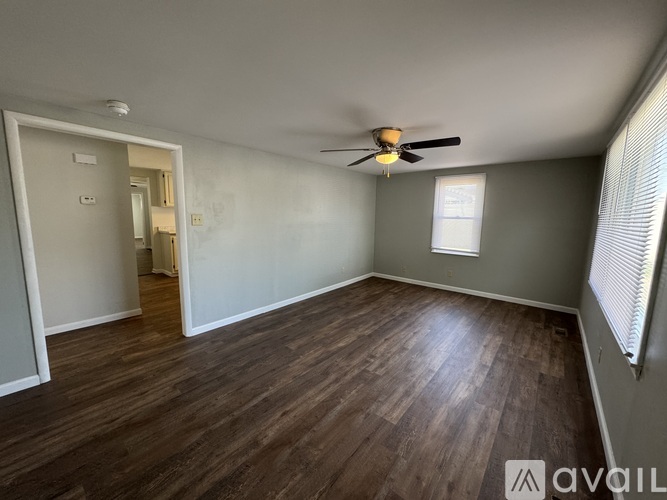 A room with wooden flooring and a ceiling fan.