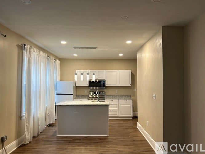 A kitchen with white appliances and cabinets is available for rent.