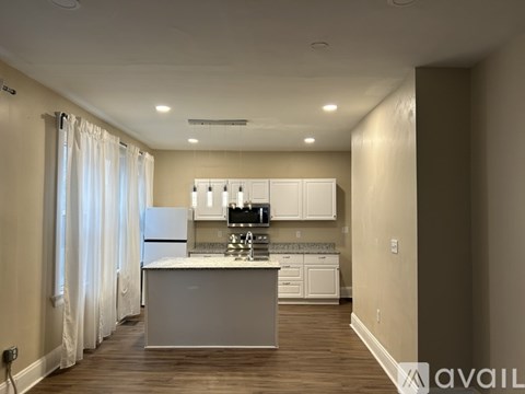 A kitchen with white appliances and cabinets is available for rent.