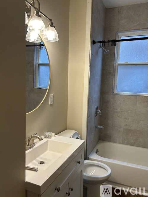 A bathroom with a sink, mirror, toilet and bathtub.