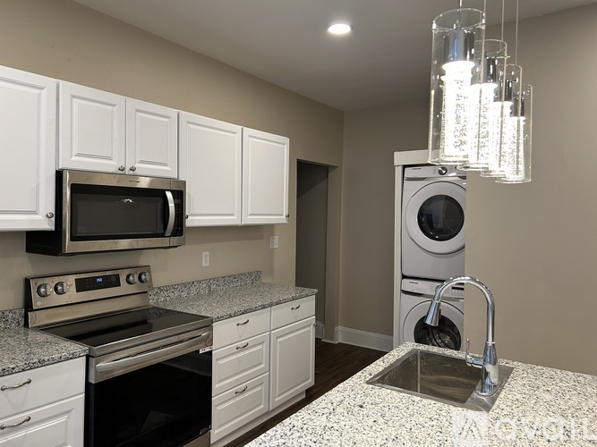 A kitchen with granite countertops and white cabinets.