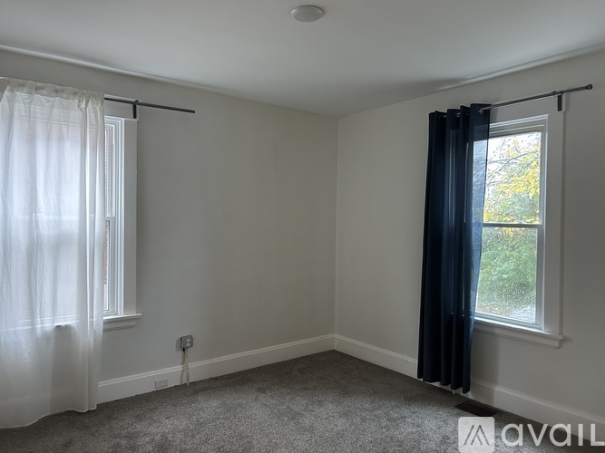 A room with a window and a curtain.